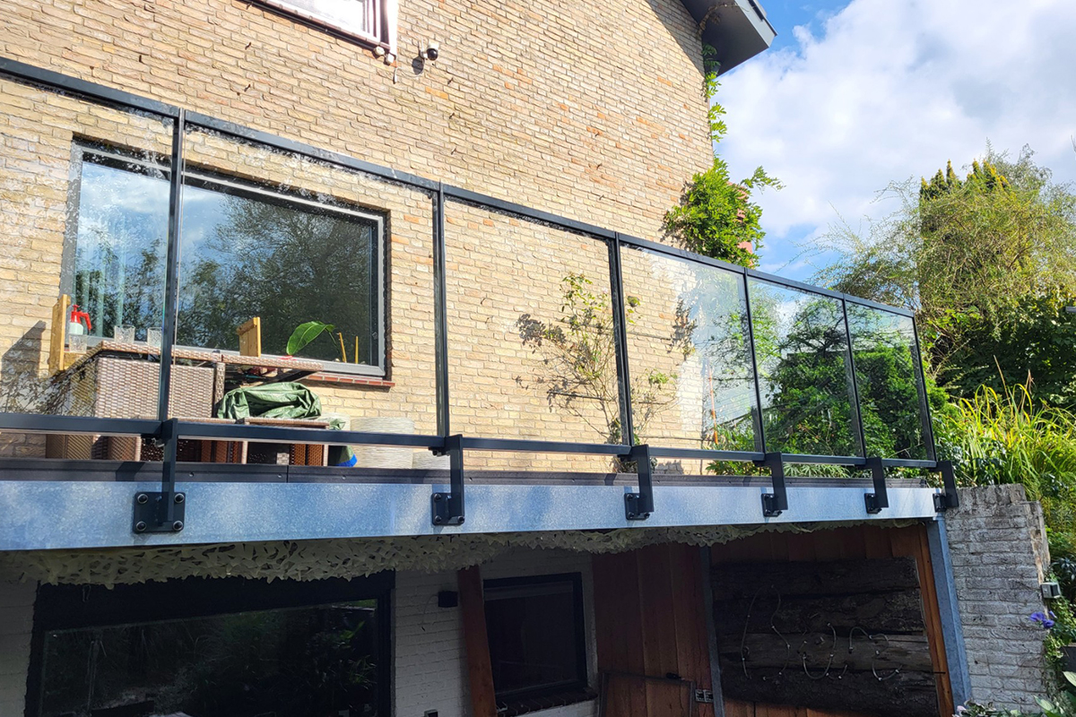 Glazen balustrade met zwarte palen, zijmontage, voor buiten Glazen balustrade met zwarte palen, zijmontage, voor buiten